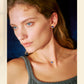 Woman wearing a necklace and earrings with a neutral background