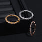 Three rings in gold, silver, and rose gold on a black surface