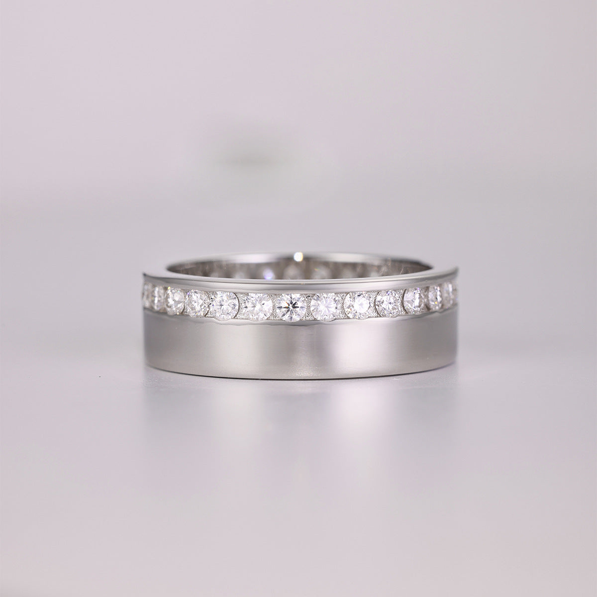 Side-by-side flat lay featuring masculine and feminine ring styles on a neutral backdrop. Alt: “Men and Women's Moissanite Eternity & Engagement Rings – Unisex Collection.”