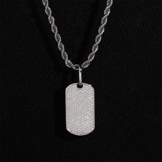 Clean white or light gray background — the chevron tag displayed on a bust form or flat surface. The geometric chevron shape catches soft light, showing high polish or brushed finish, with diamond accents sparkling subtly along the design lines.