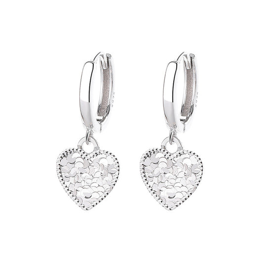 Silver heart-shaped earrings with intricate designs on a white background