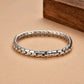 Silver bracelet with honeycomb pattern on a beige surface