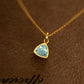 Gold necklace with a blue gemstone pendant on a brown textured background