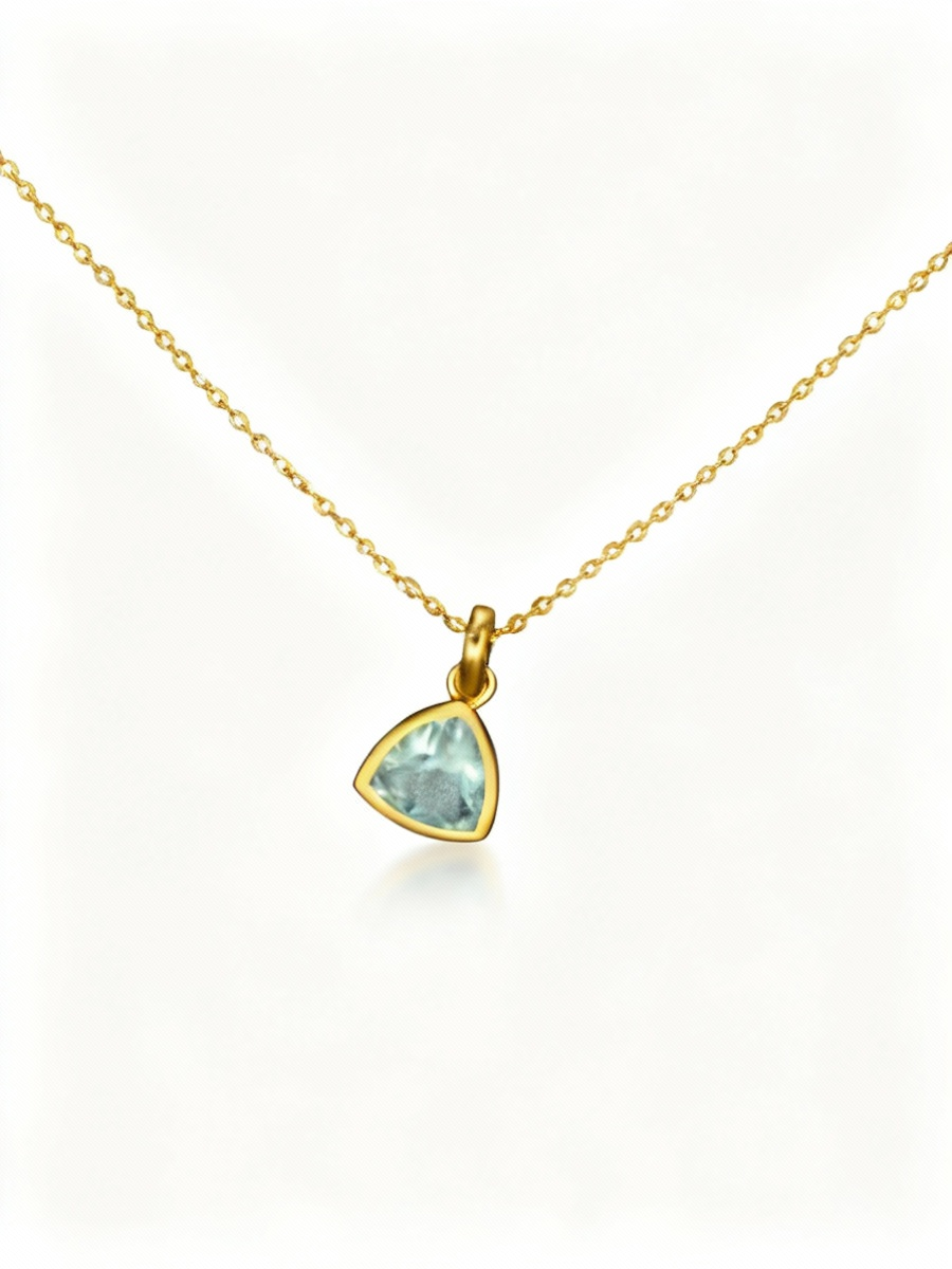 Gold necklace with a green gemstone pendant on a white background