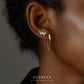 Close-up of an ear wearing gold earrings with 'YUANFAN' branding.