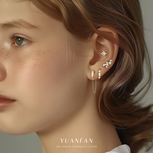 Close-up of a person wearing earrings with 'YUANFAN' branding.