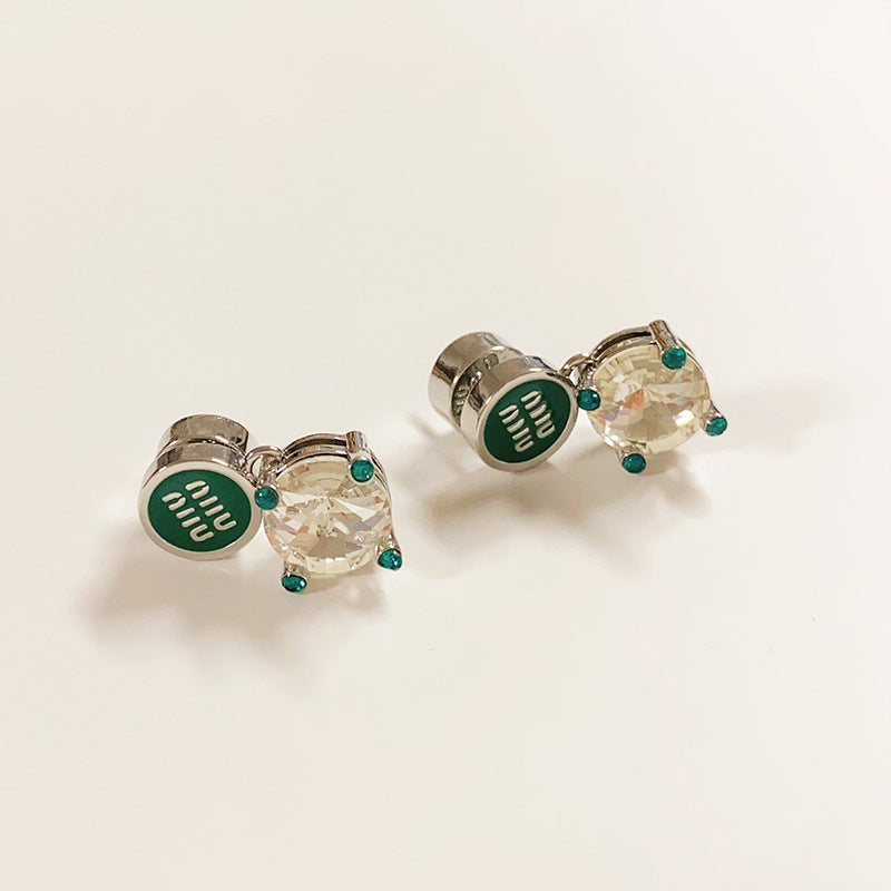 A bright, clean shot on a light grey or white background, showcasing the earrings' full shape and the sparkling contrast between metal and crystals. Alt text: "Miu Miu White Crystal and Metal Designer Earrings - Sparkling Statement Piece."