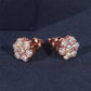 Rose gold earrings with clear gemstones on a dark blue background