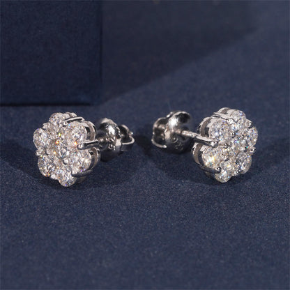 Pair of silver flower-shaped earrings on a dark blue background