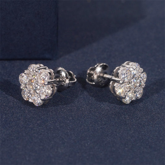 Pair of silver flower-shaped earrings on a dark blue background