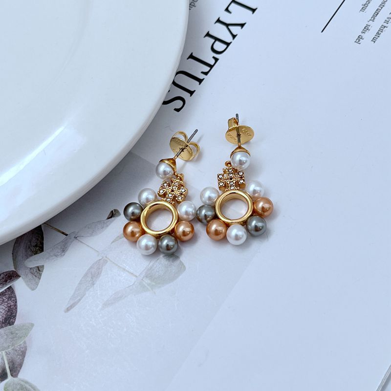Clean, vertical shot of a single earring against a plain background, showcasing the full cascade of three pearls and the delicate linking chains.