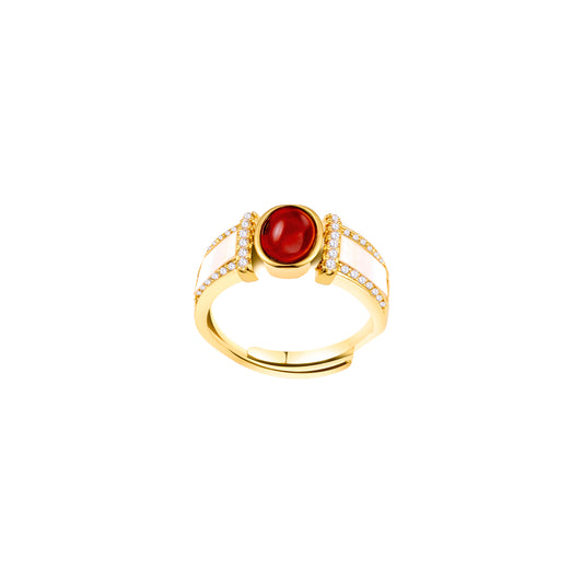 Gold ring with a red gemstone on a white background