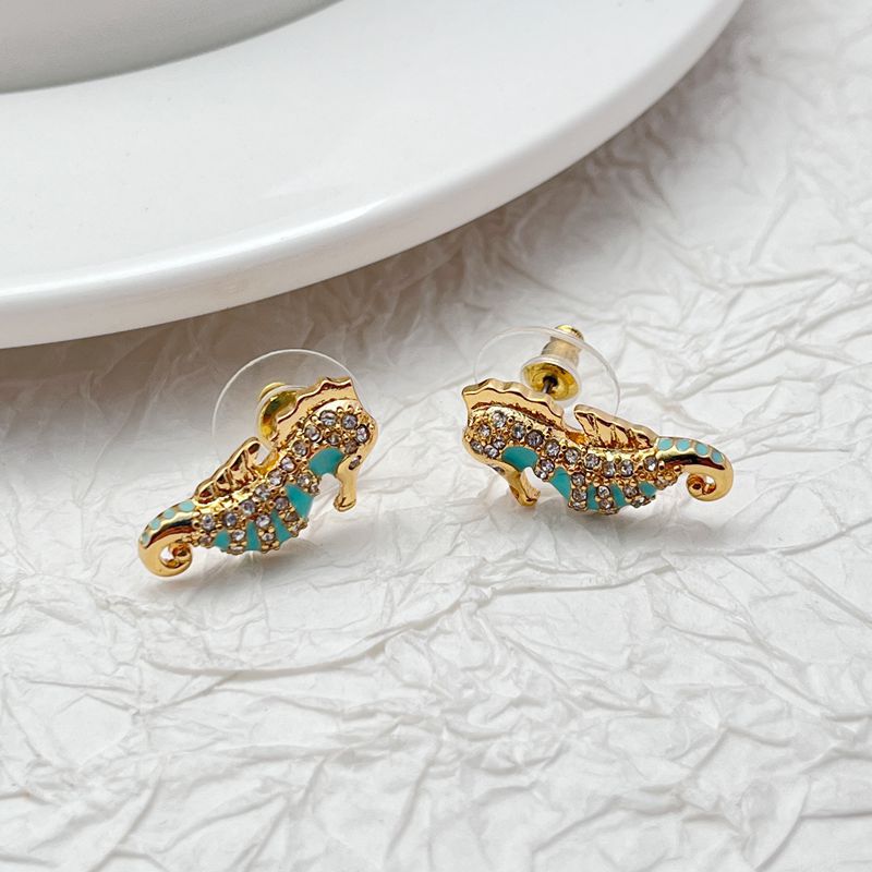  Earrings on seafoam background, showcasing seahorse with enamel and crystal eye. Alt: “New Kate Spade Seahorse Stud Earrings – Enamel Ocean Jewelry.”