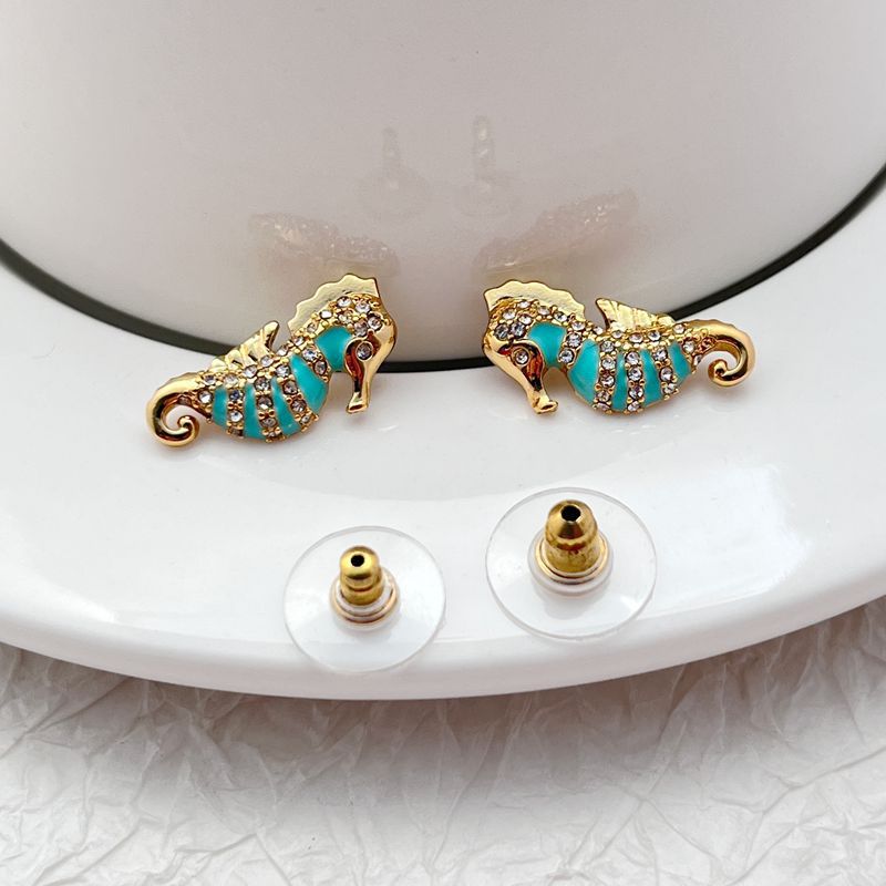  Earrings on seafoam background, showcasing seahorse with enamel and crystal eye. Alt: “New Kate Spade Seahorse Stud Earrings – Enamel Ocean Jewelry.”