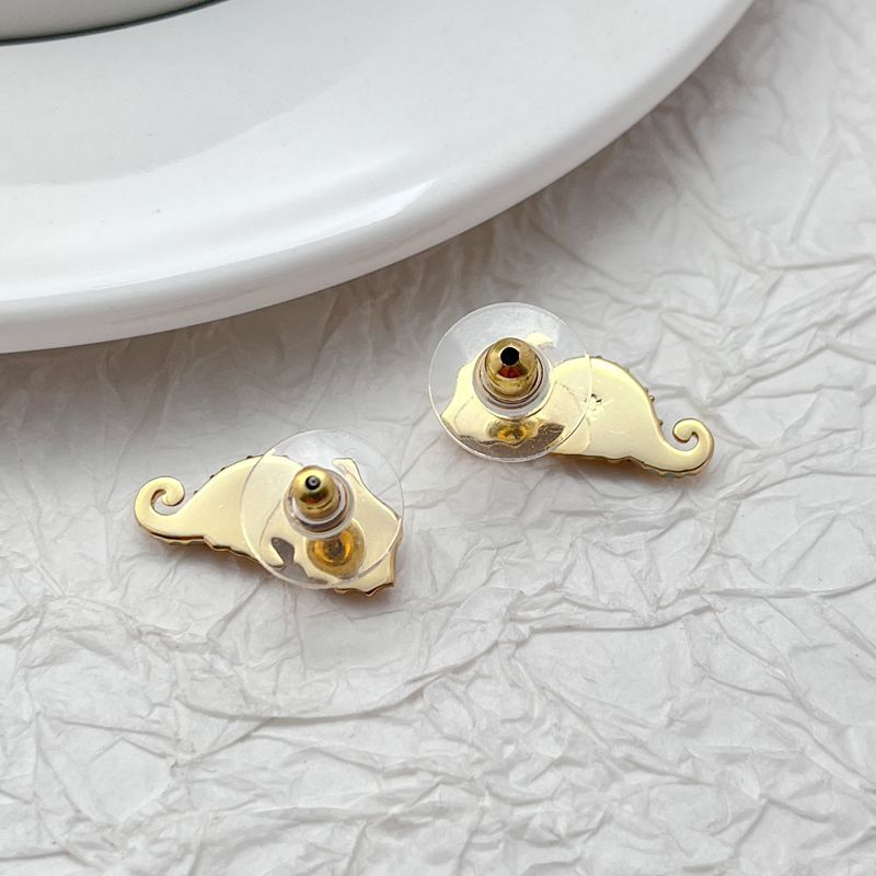  Earrings on seafoam background, showcasing seahorse with enamel and crystal eye. Alt: “New Kate Spade Seahorse Stud Earrings – Enamel Ocean Jewelry.”
