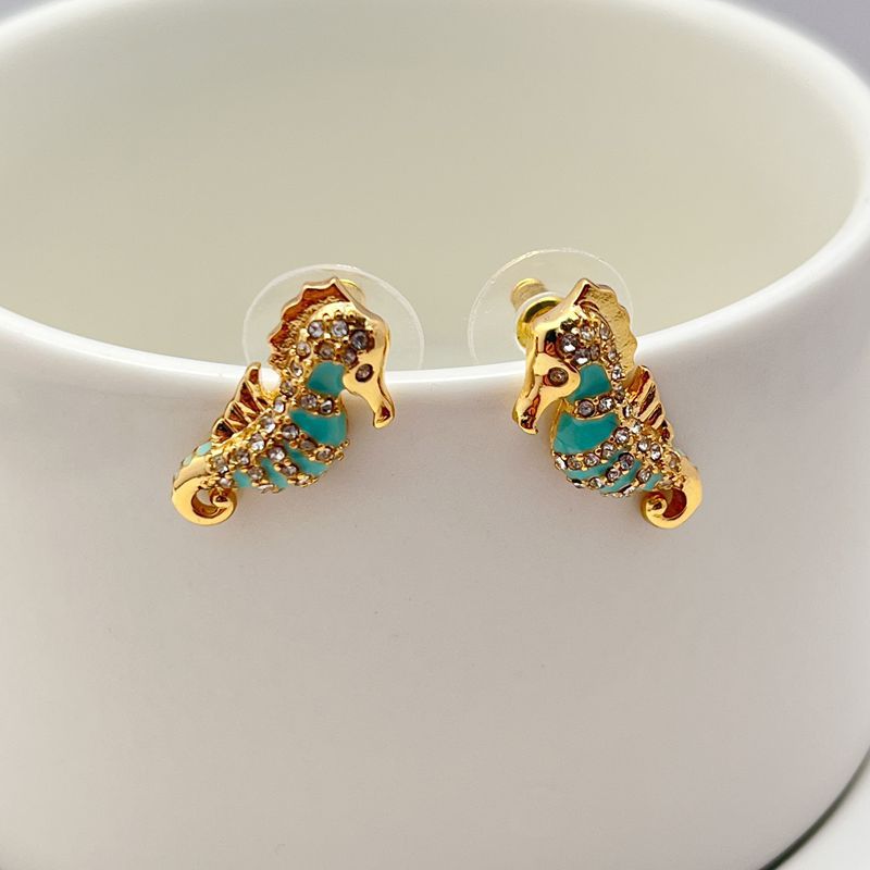  Earrings on seafoam background, showcasing seahorse with enamel and crystal eye. Alt: “New Kate Spade Seahorse Stud Earrings – Enamel Ocean Jewelry.”