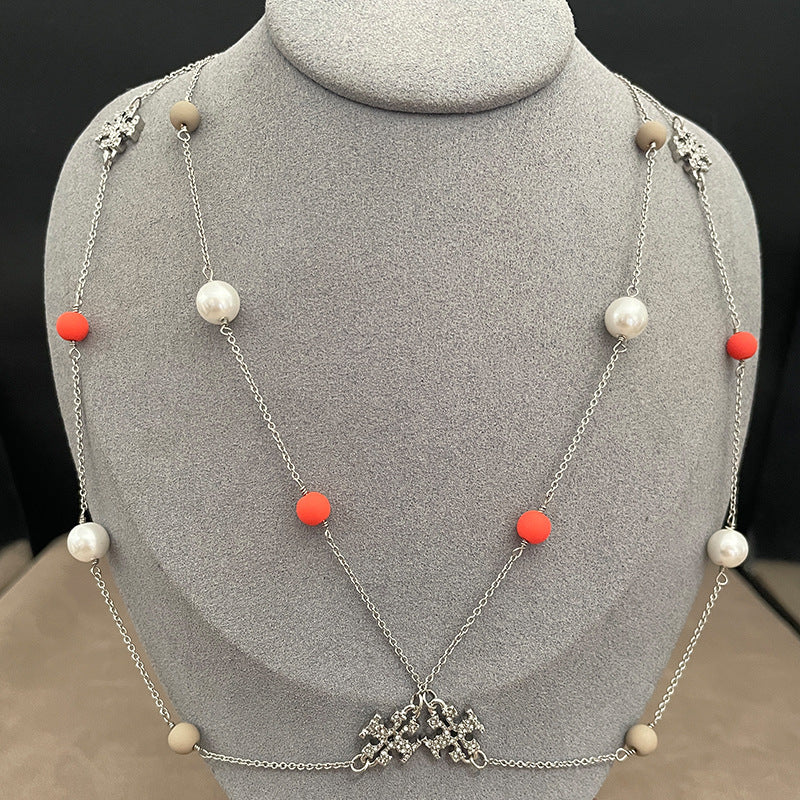Dynamic image with "Just In" typography over a styled flat lay of 3-4 brand new necklace designs against a clean, bright background.