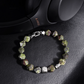 Bracelet with green beads on a black leather surface