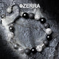 Bracelet with black, white, and gray beads on a textured surface with Zerra branding.