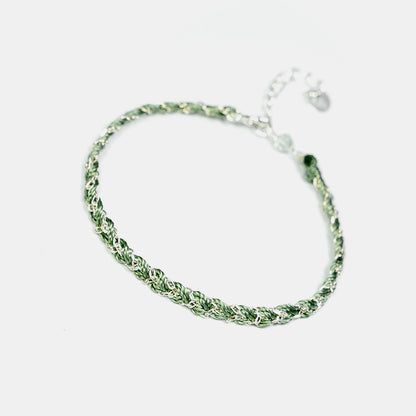 Green braided bracelet on a white background