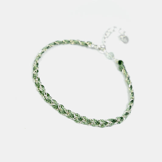 Green braided bracelet on a white background