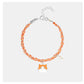 Bracelet with orange and white design on a light gray background