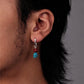 “Cultural artisan turquoise earrings worn by female model”