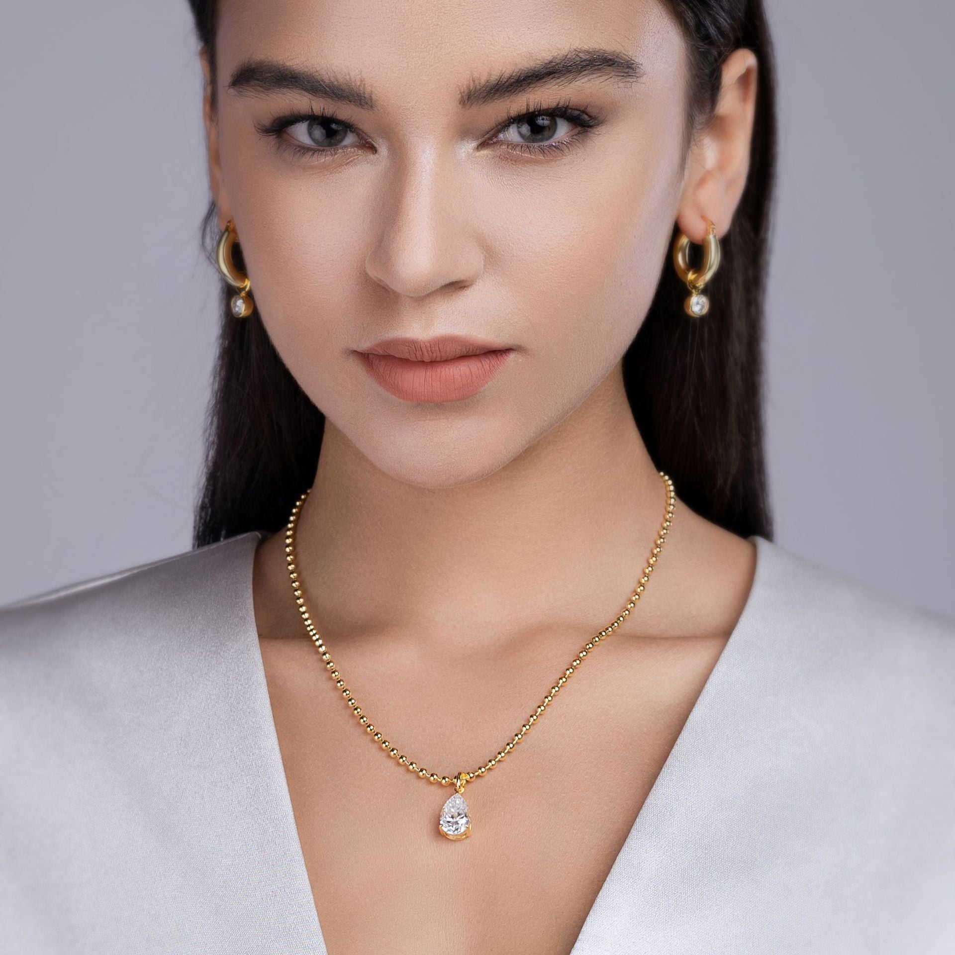 Model wearing the necklace, with focus on how it sits along the collarbone/clavicle area.