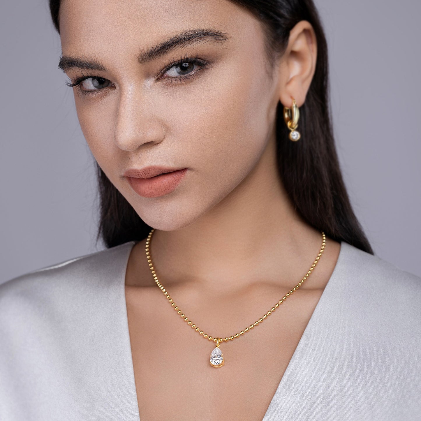 Model wearing the necklace, with focus on how it sits along the collarbone/clavicle area.