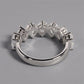 Silver ring with diamond accents on a gray background