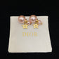 Pearl earrings Dior Gold in PearlPearl and gold star earrings on a Dior branded pillow