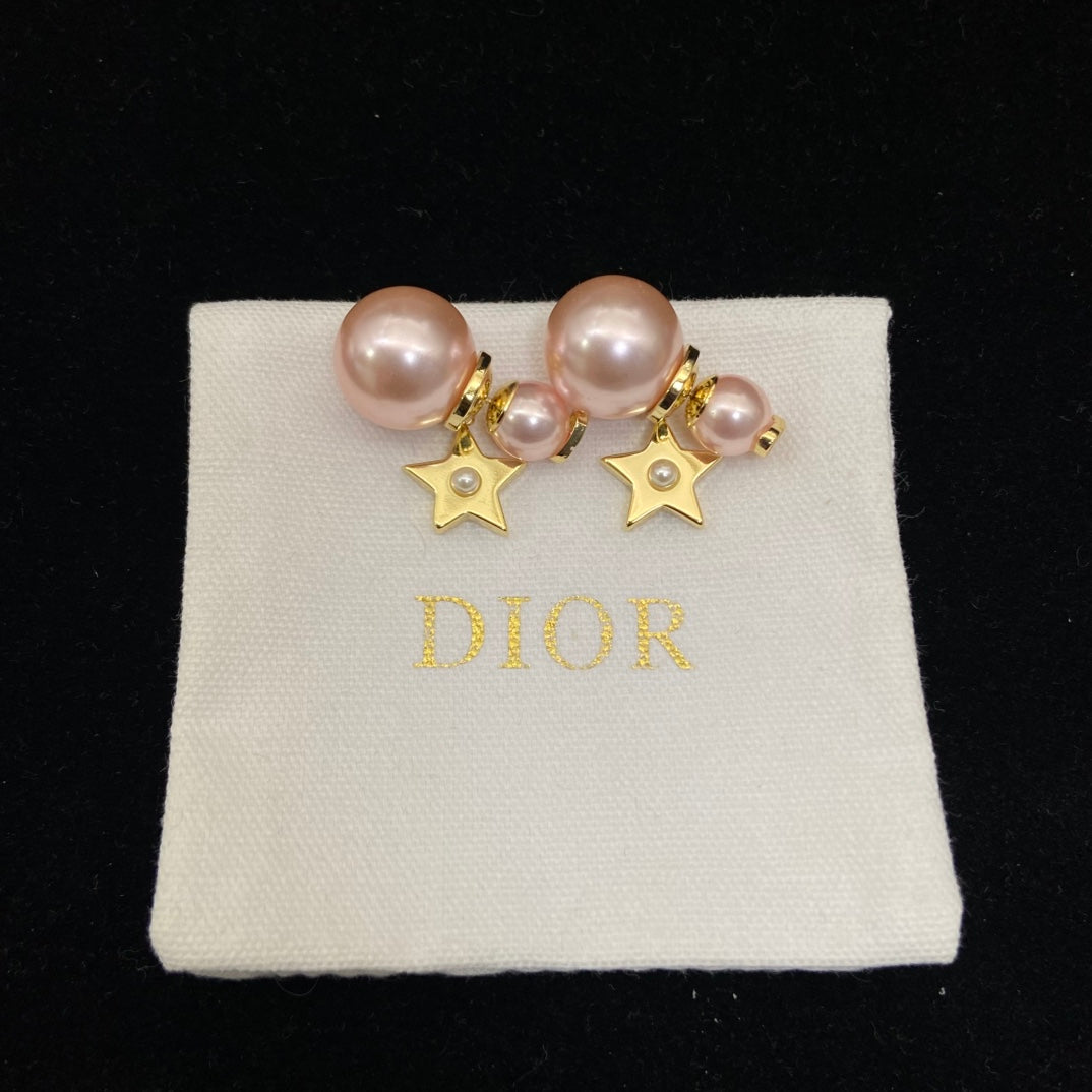 Pearl earrings Dior Gold in PearlPearl and gold star earrings on a Dior branded pillow
