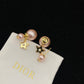 Pearl earrings Dior Gold in PearlPearl earrings with gold accents on a Dior branded pouch