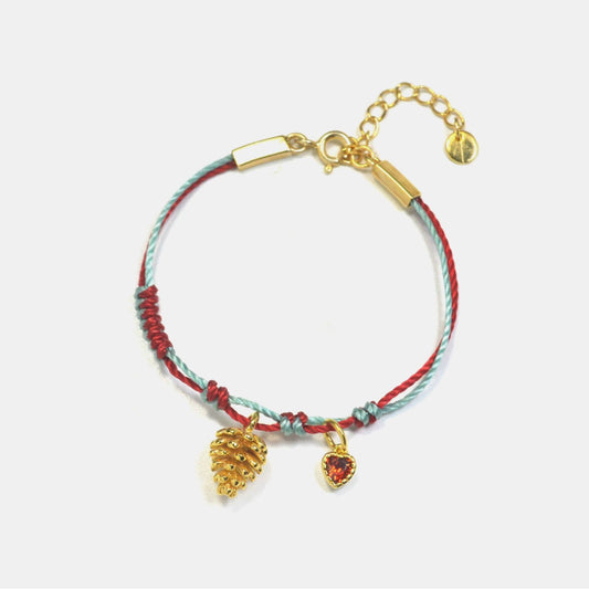 A festive yet refined piece that blends minimalist elegance with warm holiday tones. Handwoven red and green rope embraces a gold-plated 925 silver pinecone charm
