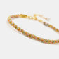 Bracelet with gold and multicolor braided design on a white background