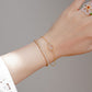 Gold bracelet on a wrist with a neutral background