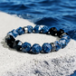 Blue beaded bracelet on a rock with water in the background