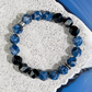 Beaded bracelet with blue and black beads on a textured surface