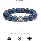 Blue beaded bracelet with a central silver emblem on a white background, featuring the brand 'Zerra'.