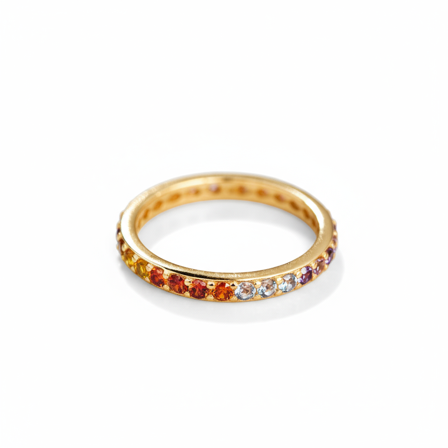 Gold ring with colorful gemstones on a white background