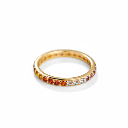 Gold ring with colorful gemstones on a white background