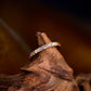 Gold ring with colorful stones on a wooden surface