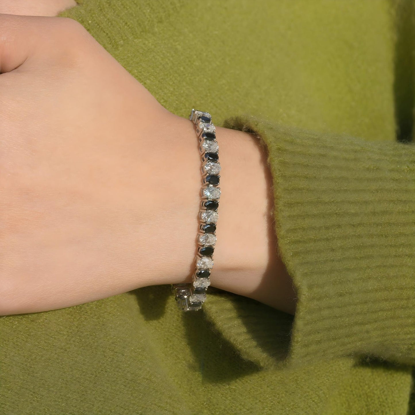 Include close-up shots showing the white and black contrast against the skin and wider shots showing the bracelet as part of an outfit.