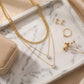 Top-down, necklaces on marble tray, styled with earrings, ring, dried flower, velvet box, warm soft tones, balanced composition, clean e-commerce aesthetic, high resolution.