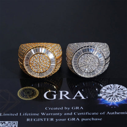 Two wide band rings displayed side by side on a glossy black surface. The left ring is gold-toned with a pavé center and baguette accents, and the right ring is silver-toned with a matching pavé center and baguette accents.