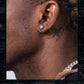Close-up of an ear with a diamond earring and a tattoo on the neck.