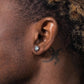Close-up of an ear with a diamond earring and a tattoo on the neck.