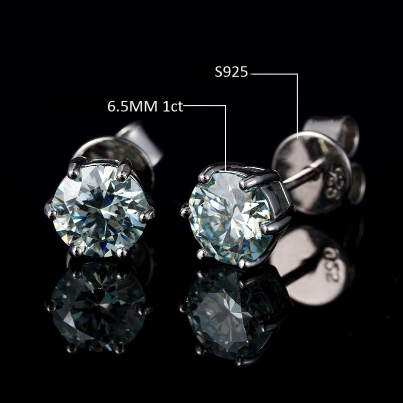 Pair of silver stud earrings with gemstones on a black background