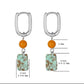 Pair of earrings with orange beads and turquoise stones, showing measurements on a white background.