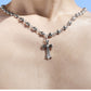 “Male model wearing punk-inspired beaded silver cross necklace”